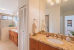 The spacious bathroom has twin vanities with sinks and granite counter tops